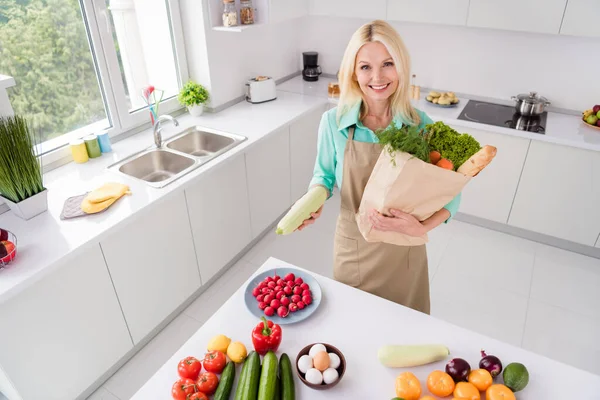 Olgun bir kadının yüksek açılı fotoğrafı mutlu bir gülümseme poşet içinde markette taze sebzeler. — Stok fotoğraf
