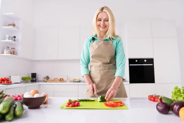 Фото зрілої жінки щаслива позитивна посмішка нарізаний овочевий ніж приготувати вечерю здорового харчування шеф-кухаря в приміщенні — стокове фото