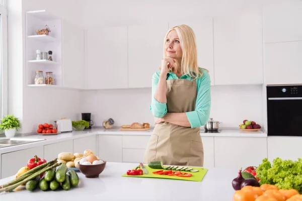 Perfil lado foto de mujer atractiva madura feliz sonrisa positiva mano tacto barbilla pensar preparar plato de receta ingredientes interior —  Fotos de Stock