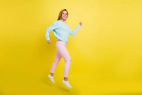 Longitud completa tamaño del cuerpo perfil vista lateral de atractiva chica alegre saltando ir aislado sobre fondo de color amarillo brillante —  Fotos de Stock