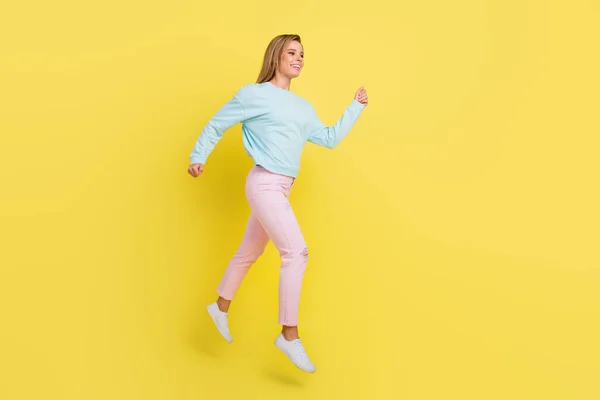 Pleine longueur vue de la taille du corps de fille gaie attrayante sautant à pied portant des vêtements confortables isolés sur fond de couleur jaune vif — Photo