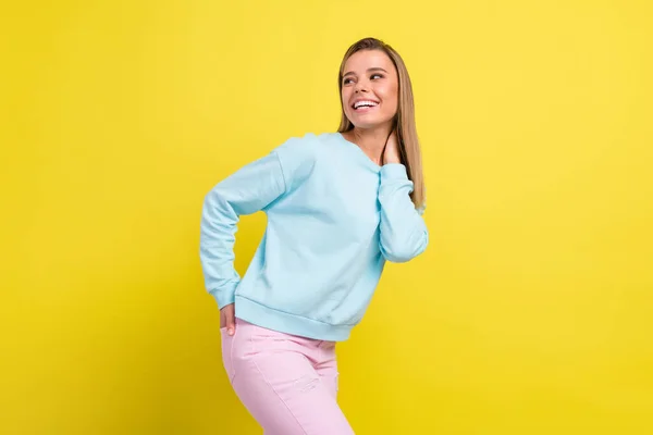 Photo of inspired girlish lady hand pocket look back empty space wear blue pullover isolated on yellow background — Stock Photo, Image