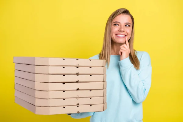 Zdjęcie ciekawa zabawna pani trzymać stos pizzy spojrzeć w górę puste miejsce myślę nosić niebieski sweter izolowany na żółtym tle — Zdjęcie stockowe
