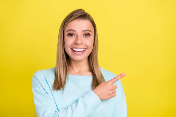 Portrait of attractive cheerful girl demonstrating new novelty copy empty space isolated over bright yellow color background — Stock Photo, Image