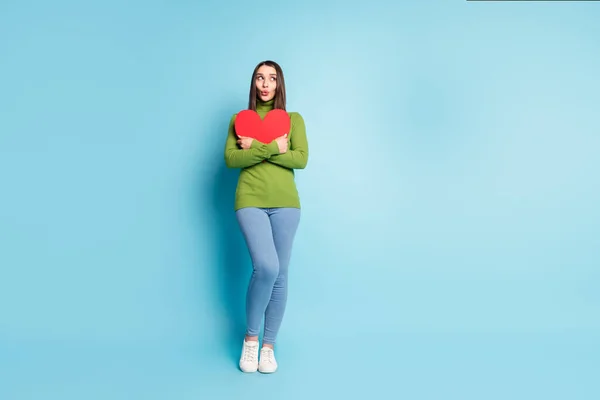 Φωτογραφία από ενθουσιασμένοι στοργική κυρία αγκαλιά κόκκινο χάρτινο σχήμα καρδιά ματιά κενό χώρο φορούν πράσινο ζιβάγκο απομονώνονται σε μπλε φόντο — Φωτογραφία Αρχείου