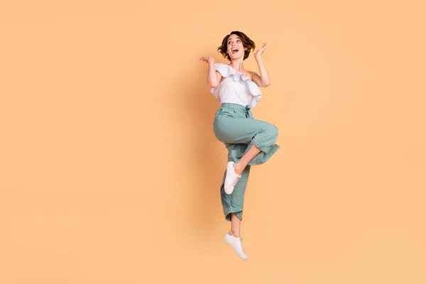 Zdjęcie podekscytowany ładna młoda dama nosić off-ramię bluzka uśmiechnięty skoki patrząc puste miejsce odizolowane beżowy kolor tło — Zdjęcie stockowe