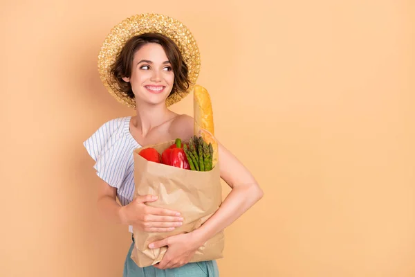 Profil boční fotografie mladé dívky kupec obchod potraviny zelenina čerstvé izolované přes béžové barvy pozadí — Stock fotografie
