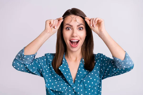 Foto de doce impressionado jovem senhora desgaste pontilhado camisa braços óculos boca aberta sorrindo isolado cinza cor fundo — Fotografia de Stock