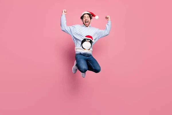 Foto av söt lycklig gentleman bära nytt år tröja leende hoppa stigande knytnävar isolerad rosa färg bakgrund — Stockfoto