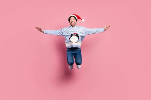 Foto av stilig söt gentleman bära nytt år tröja leende hoppa armar sidor isolerad rosa färg bakgrund — Stockfoto
