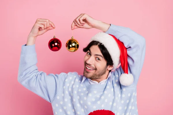 Foto de doce bonito cavalheiro desgaste novo ano suéter sorrindo segurando decoração bolas isolado cor-de-rosa fundo — Fotografia de Stock