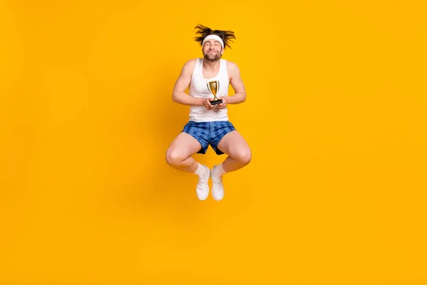 Teljes hosszúságú testméret kilátás vonzó vidám álmodozó srác ugrás szerzés csésze elszigetelt felett élénk sárga színű háttér — Stock Fotó