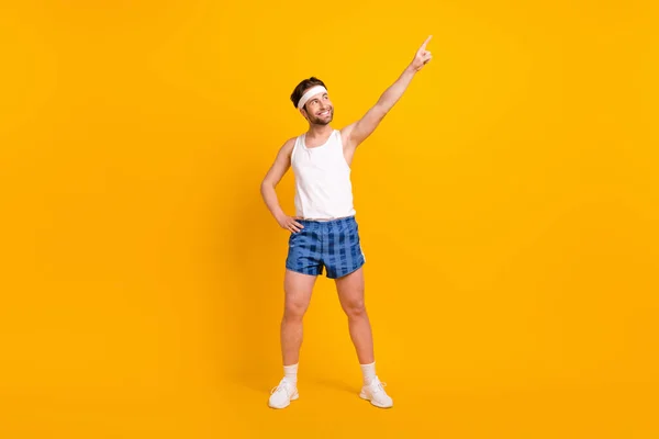 Full length body size view of attractive cheerful guy pointing forefinger doing work out isolated over bright yellow color background — Stock Photo, Image