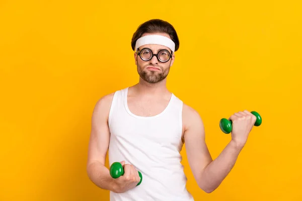 Porträt von attraktiven funky guy Nerd dabei, trainieren Muskeln Entwicklung isoliert über helle gelbe Farbe Hintergrund — Stockfoto