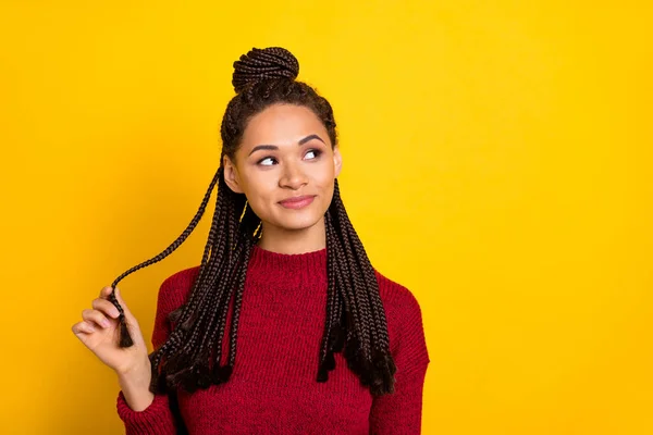 Foto de la encantadora mujer de piel oscura de ensueño usar jersey rojo sonriendo buscando espacio vacío aislado color amarillo fondo — Foto de Stock