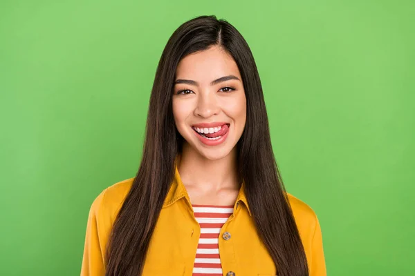 Foto de la fresca morena peinado joven dama lamer diente desgaste camisa amarilla aislada sobre fondo de color verde pastel —  Fotos de Stock