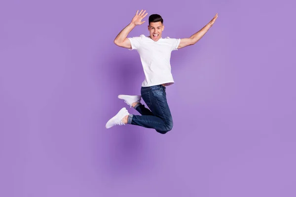 Полное фото тела веселого молодого счастливого человека прыгать вверх воздух активное хорошее настроение изолированы на фиолетовом фоне цвета — стоковое фото