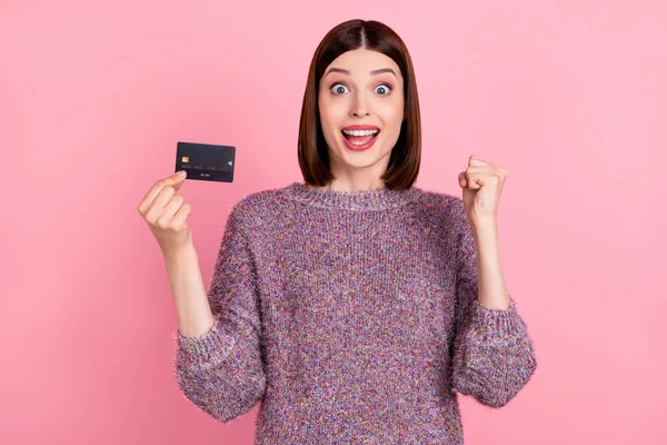 Foto av glad förvånad dam hålla betalkort glädje bära stickad pullover isolerad rosa färg bakgrund — Stockfoto