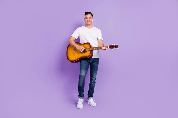 Πλήρης φωτογραφία μεγέθους των θετικών χαρούμενη χαρούμενος άνθρωπος κρατήστε τα χέρια παίζουν κιθάρα μουσικός απομονωμένο σε μωβ φόντο χρώμα — Φωτογραφία Αρχείου