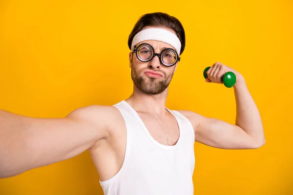 Selbstporträt des attraktiven flippigen Kerls Nerd beim Workout Bodybuilding isoliert über leuchtend gelbem Hintergrund — Stockfoto