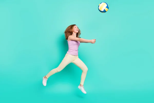 Comprimento total tamanho do corpo foto menina pulando para cima jogando voleibol isolado vibrante cor teal fundo — Fotografia de Stock