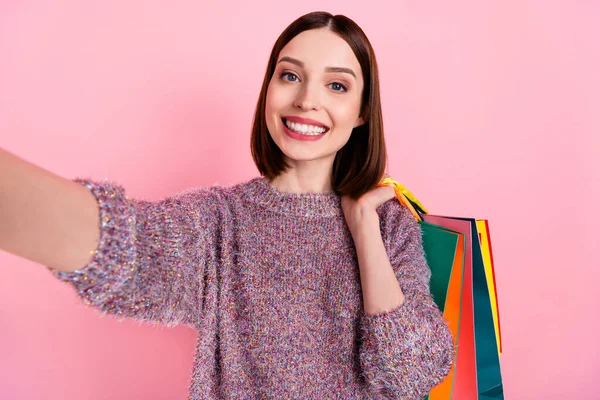 Foto de bastante shopaholic señora disparar selfie llevar bolsas de centro comercial desgaste de punto suéter aislado de color rosa de fondo —  Fotos de Stock