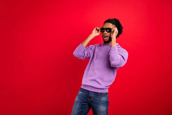 Retrato de atractivo chico morena alegre asombrado tocando especificaciones espacio de copia aislado sobre fondo de color rojo brillante —  Fotos de Stock