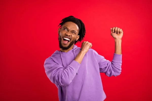 Foto retrato hombre sonriendo bailando en fiesta buscando copyspace aislado vibrante color rojo fondo — Foto de Stock