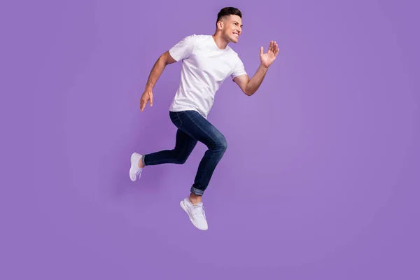Full storlek profil sida foto av ung man glad positiv leende hoppa gå promenad springa isolerad över violett färg bakgrund — Stockfoto