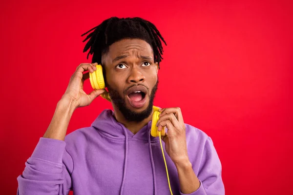 Foto retrato hombre escuchando música en auriculares aislados insatisfechos vibrante fondo de color rojo —  Fotos de Stock