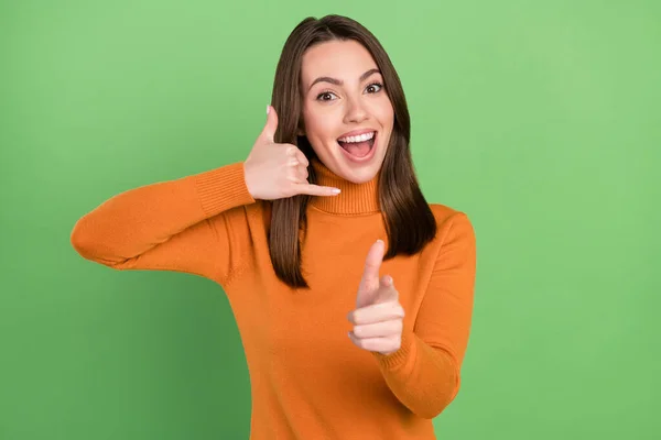 Foto retrato mulher sorrindo mostrando chamar-me sinal apontando dedo para você isolado pastel cor verde fundo — Fotografia de Stock