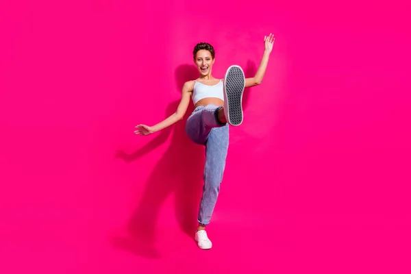 Longitud completa vista del tamaño del cuerpo de la atractiva chica alegre que se divierte mostrando la suela aislada sobre el fondo de color magenta rosa brillante —  Fotos de Stock