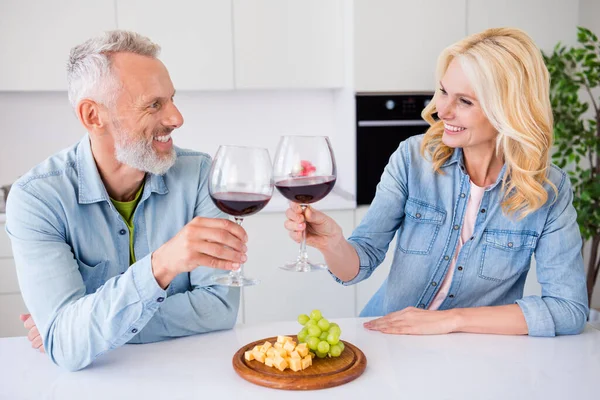Foto de sorrindo alegre casal encantador esposa e marido bebendo vinho clink torrada comer aperitivo comemorar data de casa — Fotografia de Stock