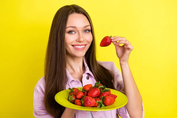 Photo portrait jeune femme gardant assiette avec des fraises souriant en été isolé fond de couleur jaune vif — Photo