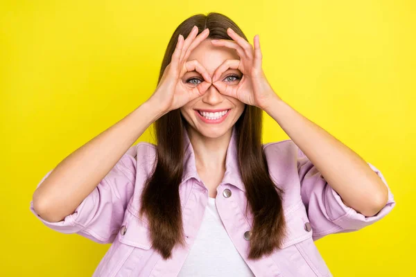 Portré vonzó vidám lány mutatja ok-jel, mint a szemüveg szórakozás elszigetelt felett élénk sárga háttér — Stock Fotó