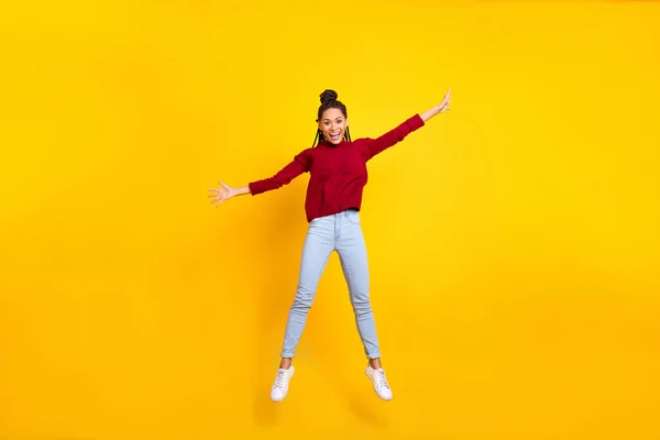 Фотографія повної довжини чарівної солодкої темної шкіри леді носить червоний пуловер, посміхаючись стрибаючи високий ізольований жовтий колір фону — стокове фото