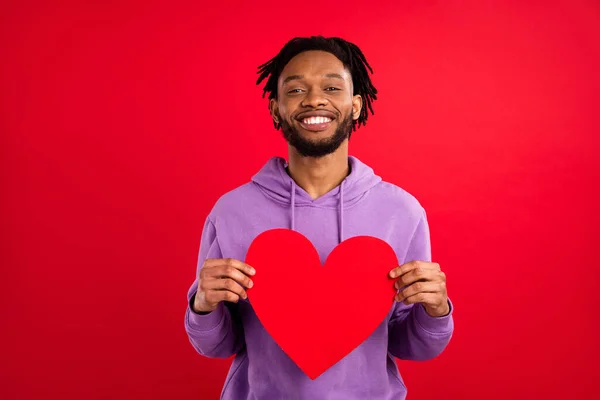 Fényképezés portré férfi mosolygós bemutató piros szív képeslap elszigetelt élénk piros szín háttér — Stock Fotó