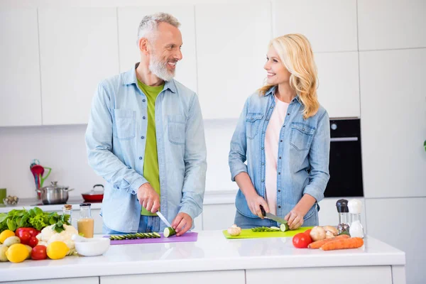 Foto de buen humor sonriente pareja positiva preparar comida desayuno juntos esposa y marido cortar el pepino chuleta — Foto de Stock