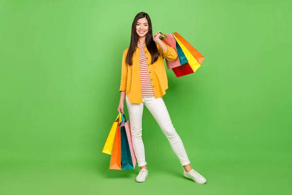 Foto de larga duración de la bella dama milenaria morena con bolsos usan pantalones de camisa aislados en el fondo de color verde —  Fotos de Stock