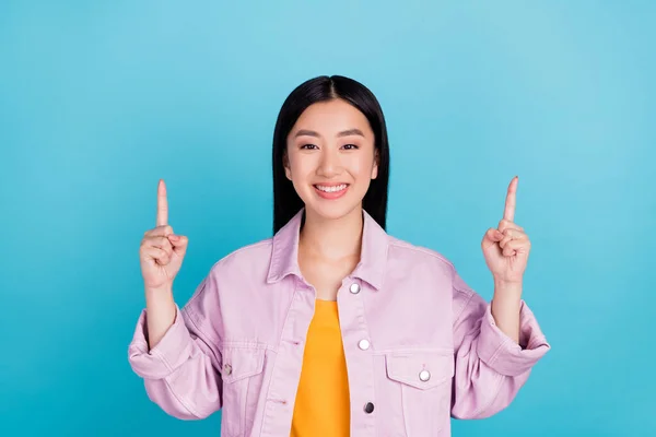 Retrato de chica alegre atractiva apuntando hacia arriba espacio de copia ad solución mirada aislada sobre fondo de color azul brillante —  Fotos de Stock