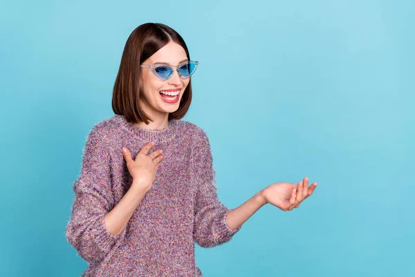 Fénykép vicces gondtalan hölgy néz üres tér nevetés kopás napszemüveg kötött pulóver elszigetelt kék szín háttér — Stock Fotó