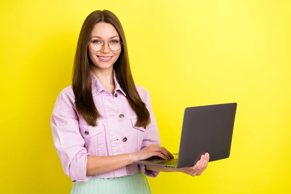 Foto porträtt ung kvinna bär glasögon arbetar på laptop isolerad levande gul färg bakgrund — Stockfoto