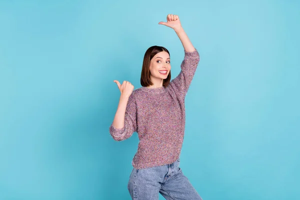 Photo of funny lovely lady indicate thumbs empty space wear knitted sweater isolated blue color background — Stock Photo, Image