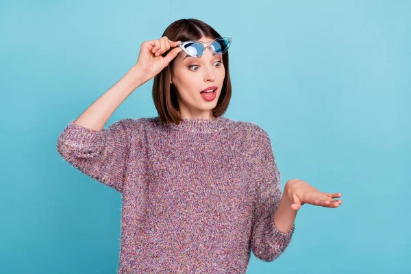 Fénykép az izgatott hölgy néz friss csiszolt ujj körmök viselnek napszemüveget kötött pulóver elszigetelt kék színű háttér — Stock Fotó