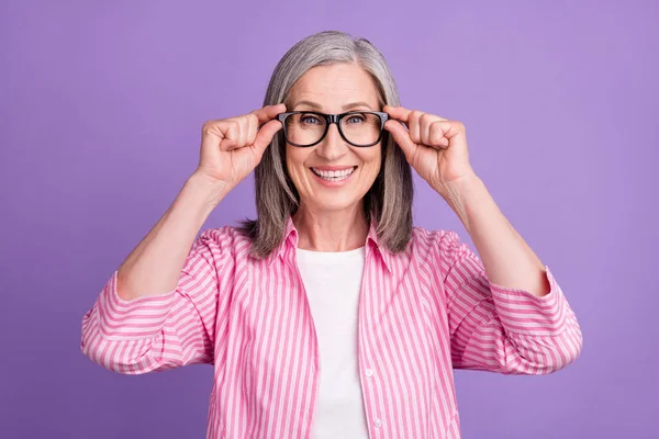 Foto av glad mogen kvinna glad positiv leende händer röra glasögon säker isolerad över lila färg bakgrund — Stockfoto