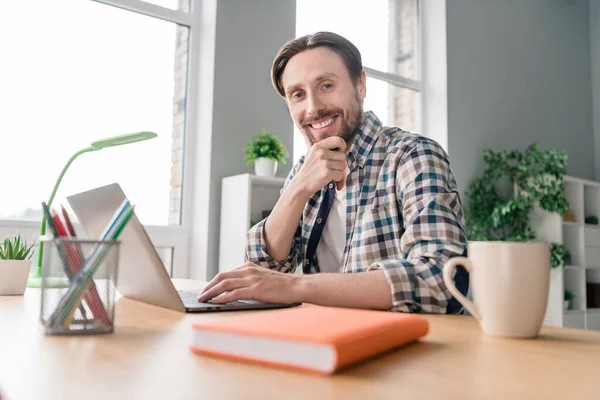 Foto de adorable hombre joven reflexivo usar camisa a cuadros sonriendo mesa de estar charlando gadget moderno interior casa oficina — Foto de Stock