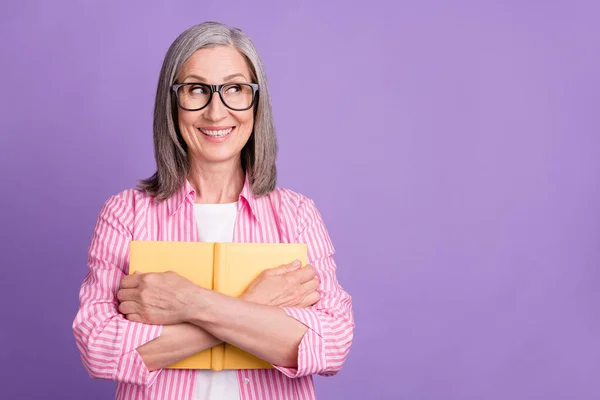 Foto van oude vrouw gelukkig positieve glimlach knuffel knuffel boek literatuur nieuwsgierig blik lege ruimte geïsoleerd over paarse kleur achtergrond — Stockfoto