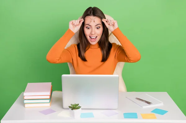 Retrato de atraente alegre menina surpreso trabalhando remotamente leitura relatório financeiro isolado sobre fundo de cor verde brilhante — Fotografia de Stock