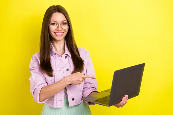 Foto retrato jovem mulher usando óculos apontando dedo computador isolado vívido cor amarela fundo — Fotografia de Stock