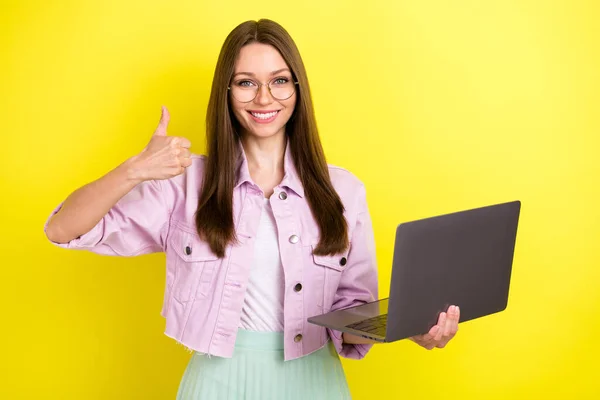 Retrato de menina alegre atraente usando laptop it tart-up projeto mostrando thumbup isolado sobre fundo de cor amarelo brilhante — Fotografia de Stock